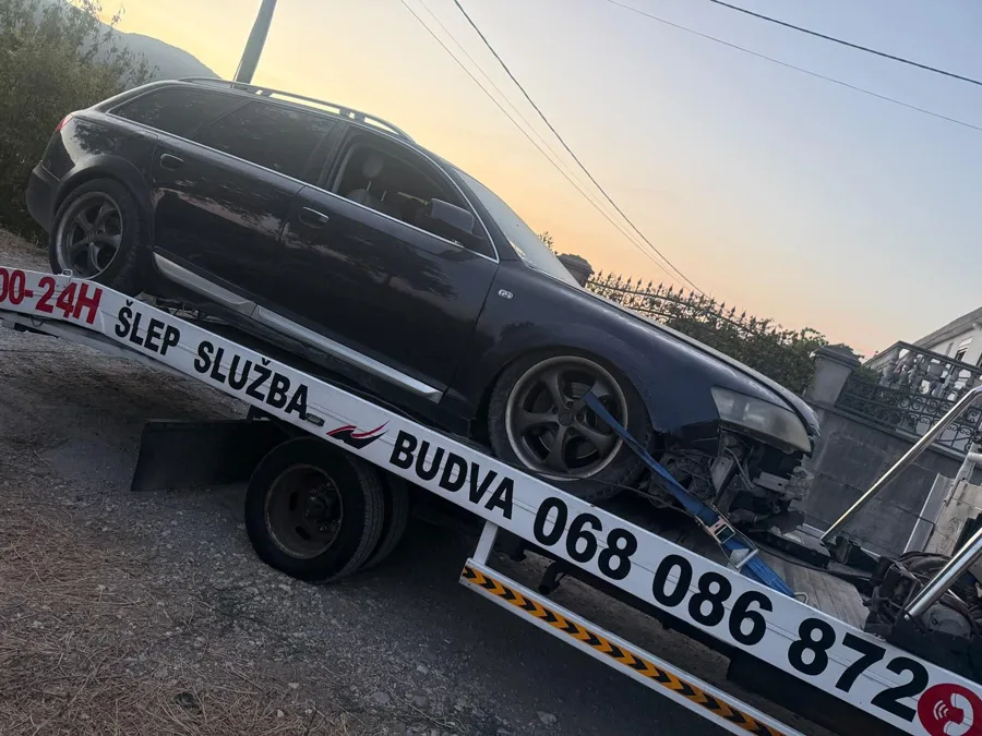 Audi A6 Allroad na platformi šlep vozila u zalazak sunca