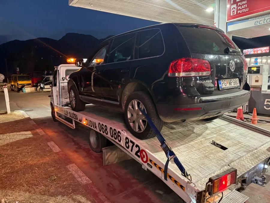 VW Touareg na šlep vozilu na benzinskoj pumpi u sumrak